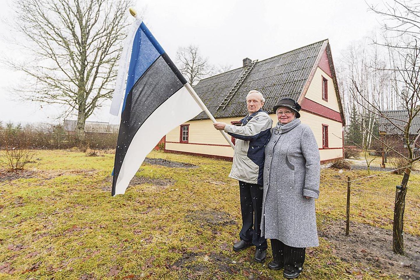 Jaan ja Helle Roosnurm hoiavad ajaloolist Eesti lippu kui kullatera.