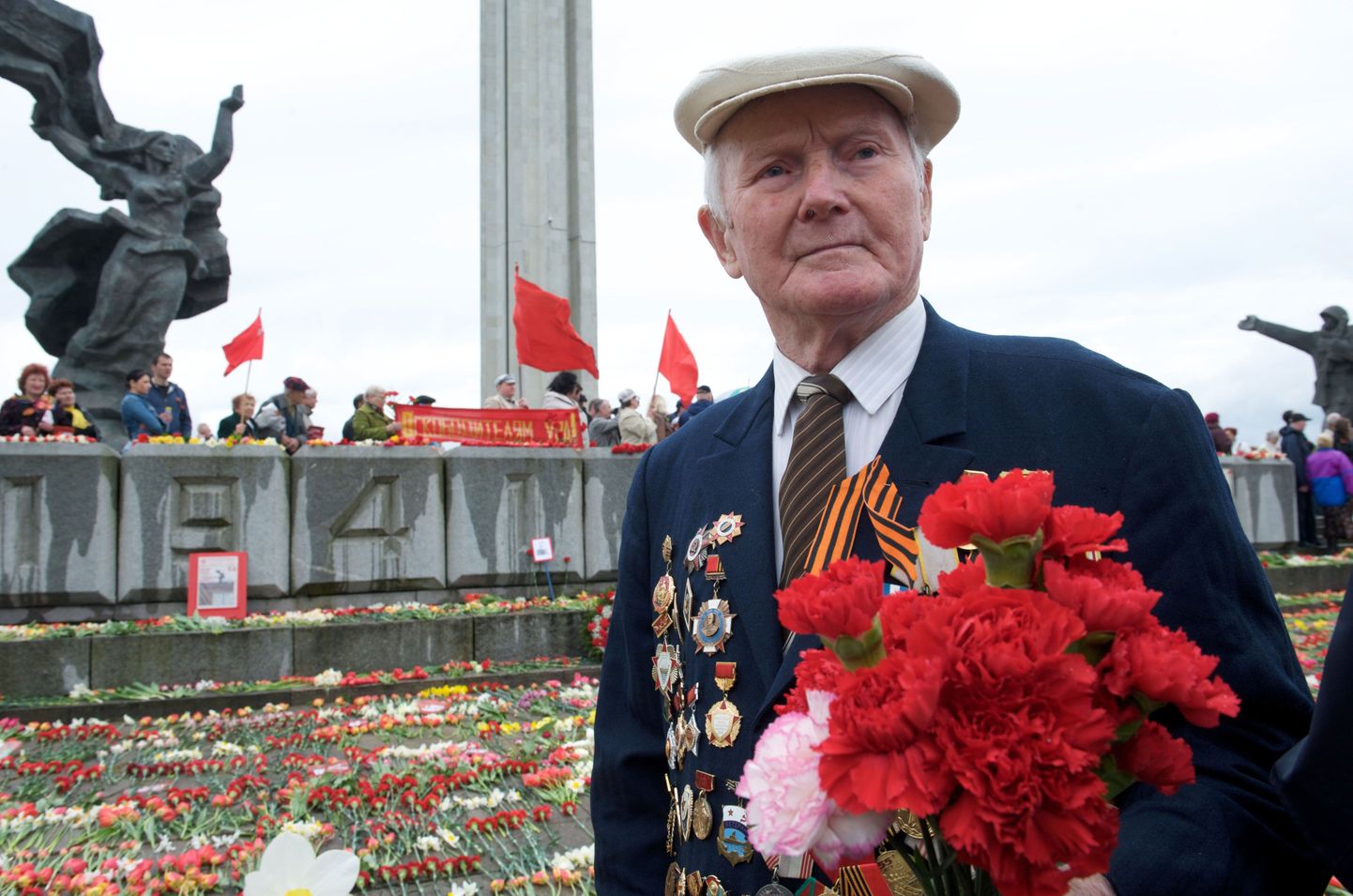 Punaarmee veteran 2009. aasta 9. mail asetamas lilli Riias asuva Teise maailmasõja monumendi jalamile.