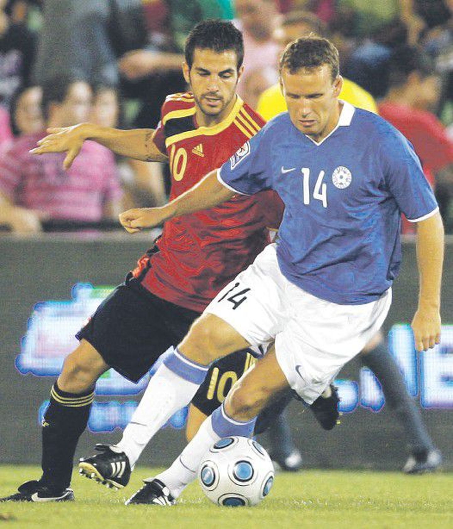 Константин Васильев (справа) ведет борьбу за мяч с полузащитником сборной Испании Франсеском Фабрегасом на отборочном матче чемпионата мира 2010 года.
