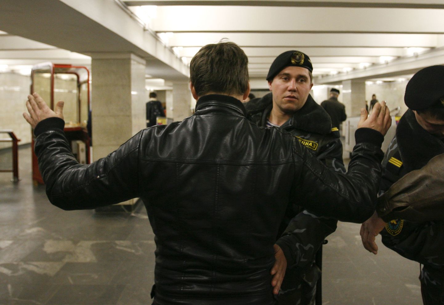 Valgevene julgeolekutöötaja kontrollimas metrooreisijat.