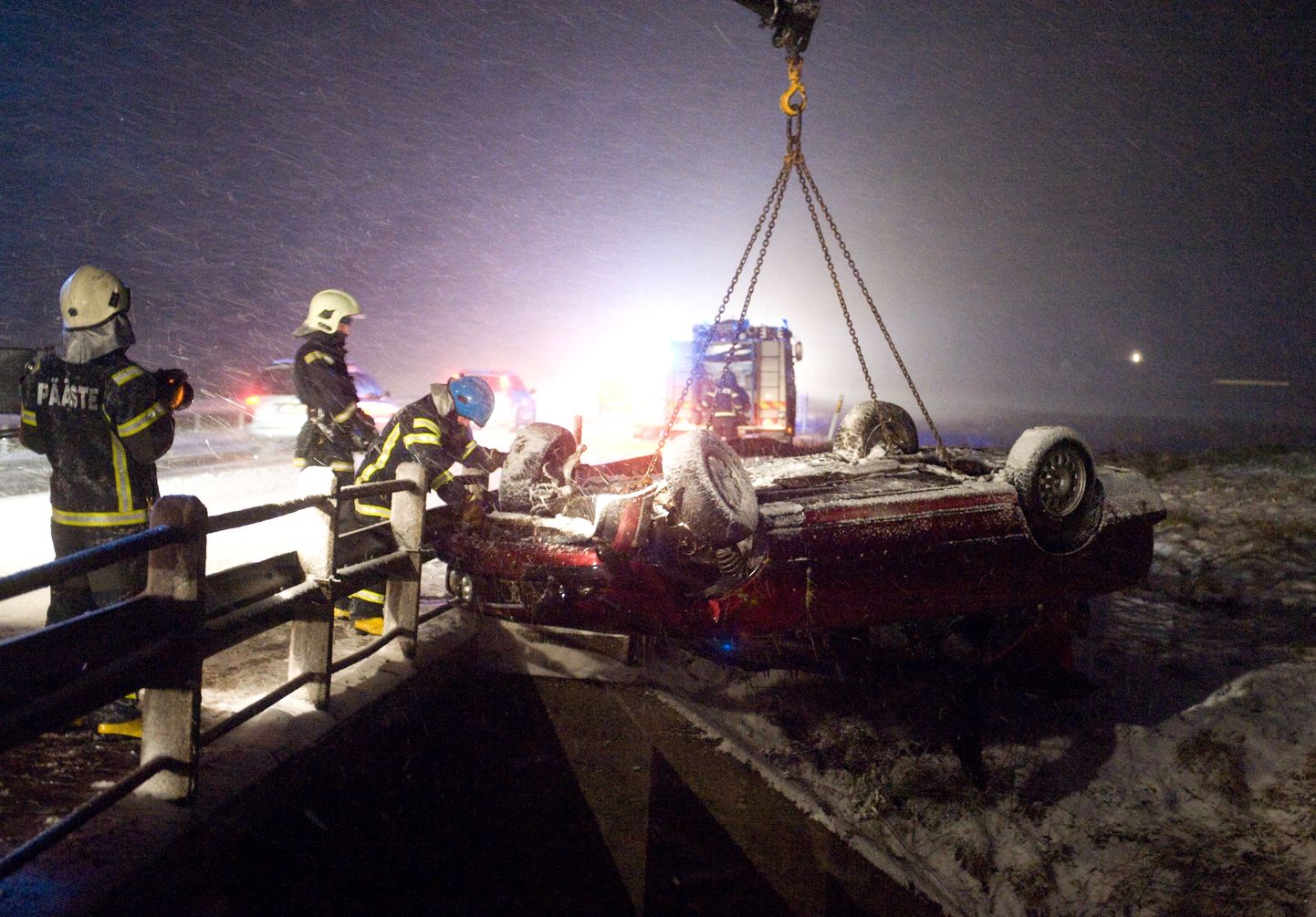 Päästjad 9. detsembril Tartu maanteel Kuivajõel avarii tõttu jõkke sõitnud autot välja sikutamas.