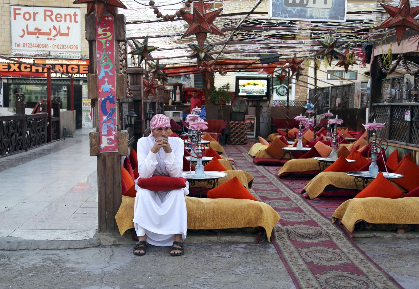 Töötaja tühja Sharm el-Sheikhi kohviku ees kliente ootamas.