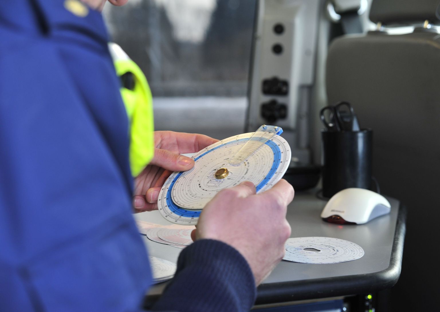 Liikluspolitseinik kontrollimas veoautojuhte. Pildil sõidumeerik.