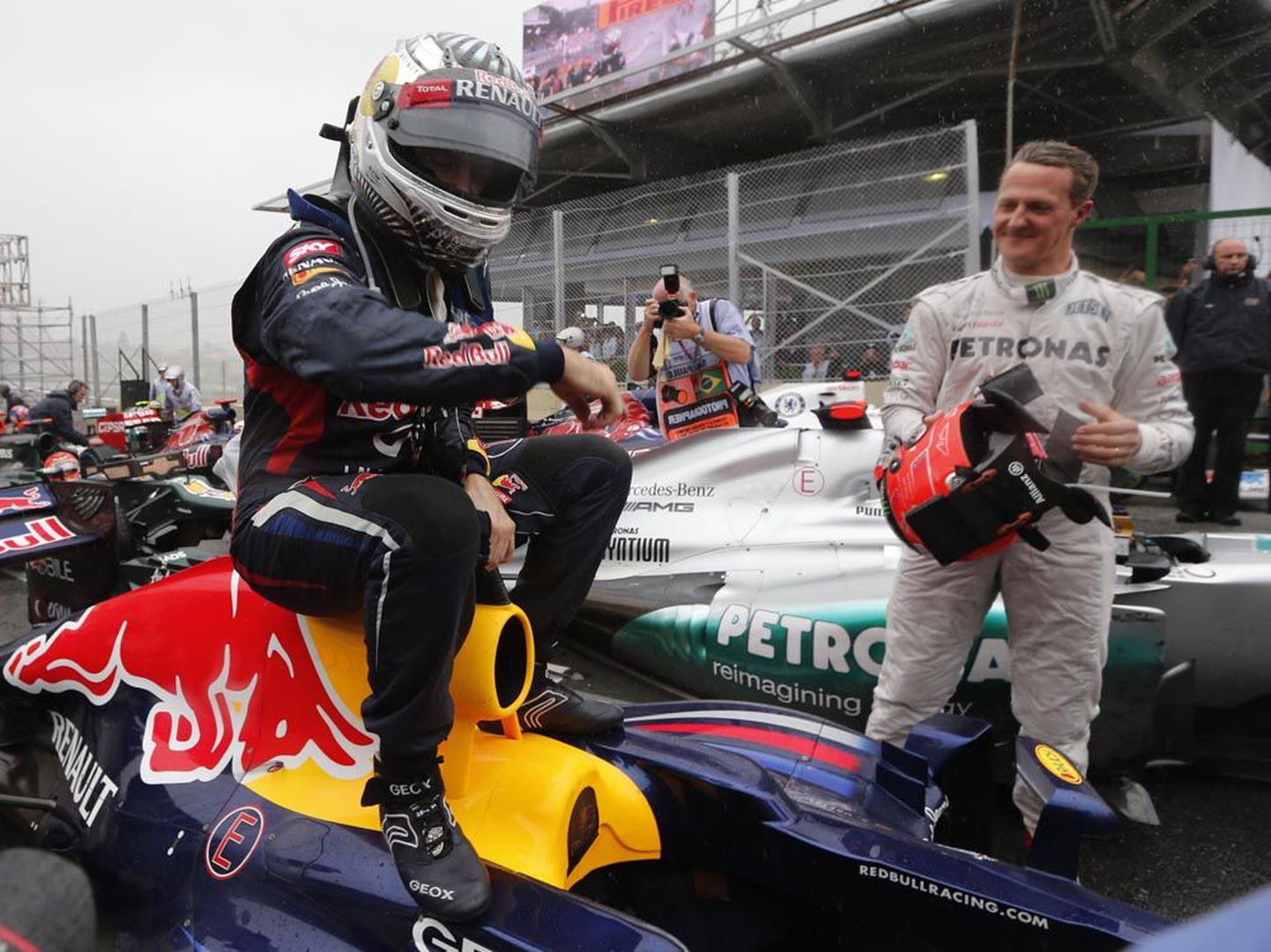 Karjääri viimase võistluse pidanud seitsmekordne vormel-1 sarja maailmameister Michael Schumacher (paremal) vaatab, kuidas võidurõõmus Sebastian Vettel istub oma Red Bulli vormeli peale ja tähistab kolmandat järjestikust tiitlit.