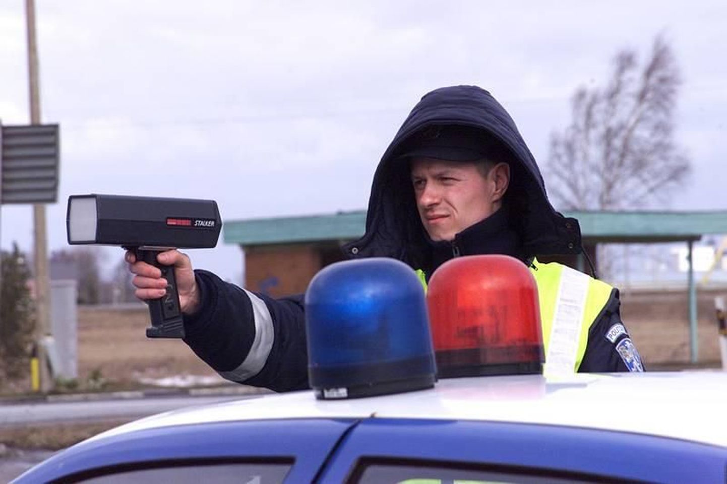 Полицейский измеряет скорость движения транспорта.