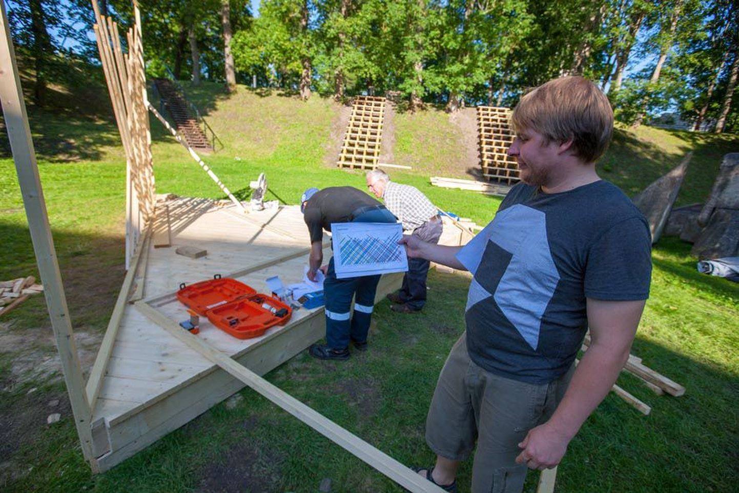 Arvamusfestivali üks korraldajatest Maiko Kesküla näitab plaani, mille järgi vabatahtlikud lava ehitavad.