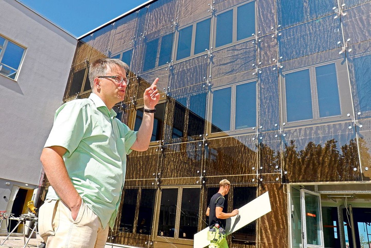 Tamme gümnaasiumi direktor Ain Tõnisson näitab Ülar Linnuste tammeteemalist fassaadikujundust.