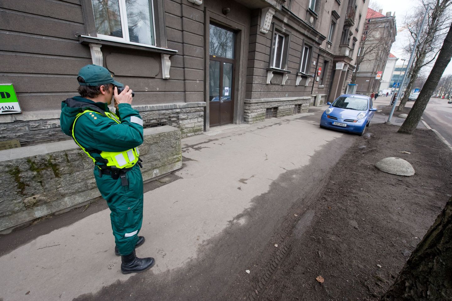 Munitsipaalpolitsei ametnik fikseerib valesti parkivaid autosid.