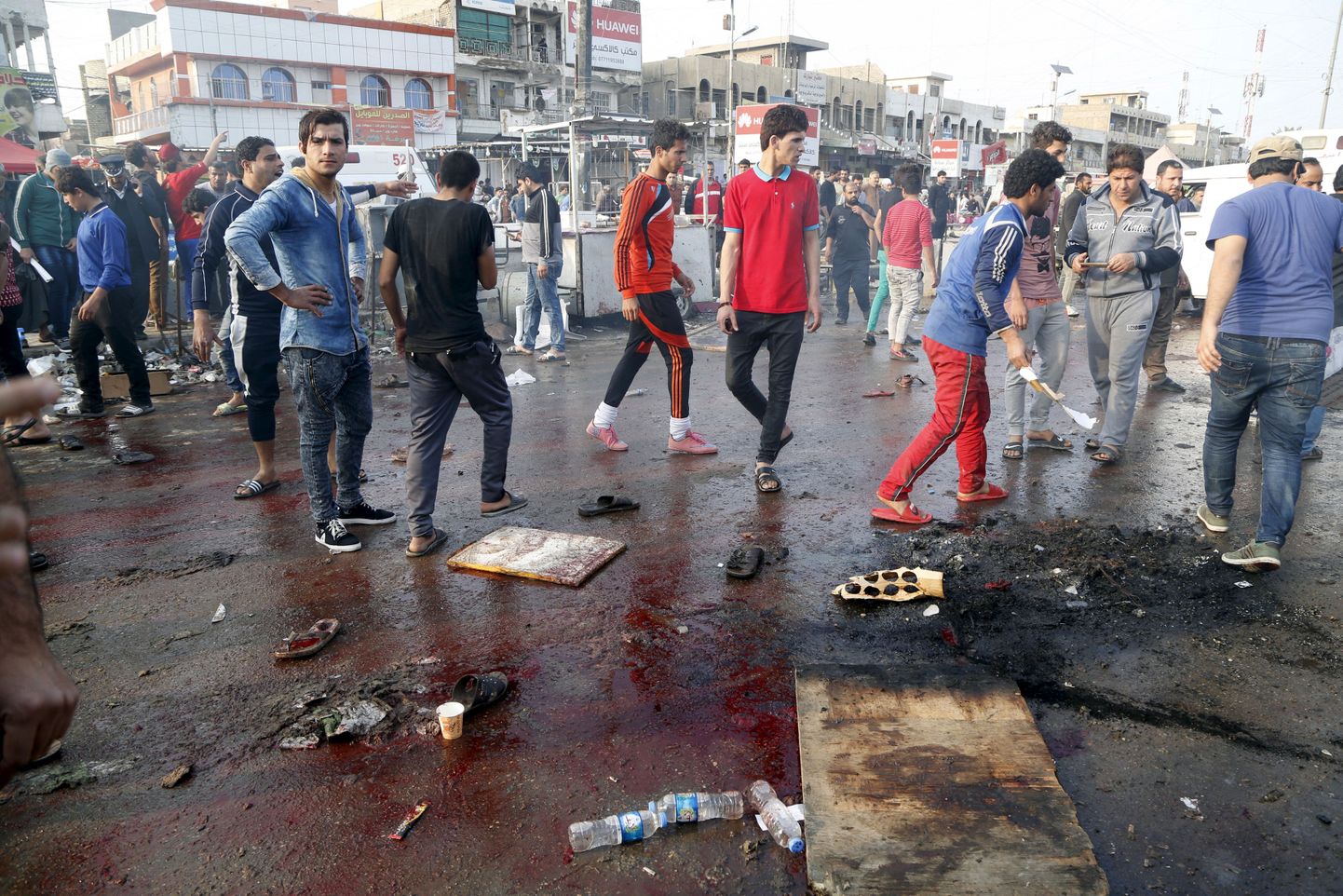 Kohalikud kogunemas Sadr City turul koha ümber, kus enesetapupommar end õhkis.