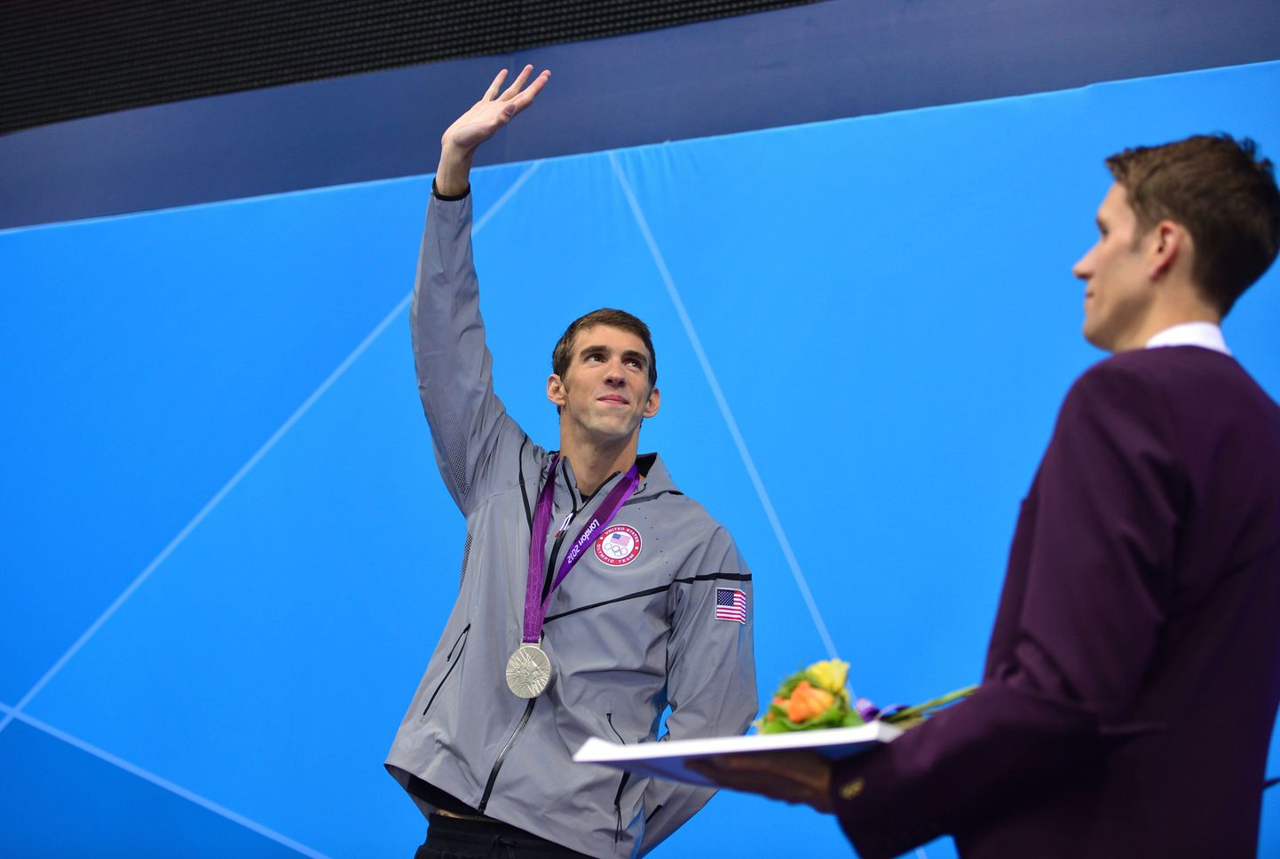 US swimmer Michael Phelps  poses on the podium after winning silver in the men's 200m butterfly final during the swimming event at the London 2012 Olympic Games on July 31, 2012 in London.  AFP PHOTO / FABRICE COFFRINI