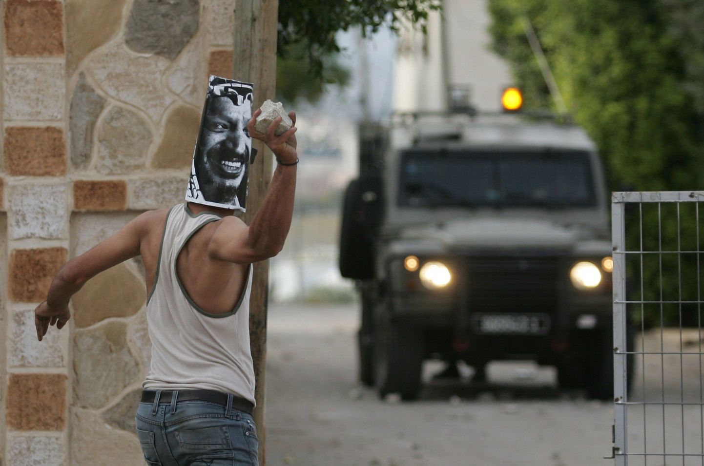 Noor palestiinlane viskasmas kivi Iisraeli sõjaväe auto suunas