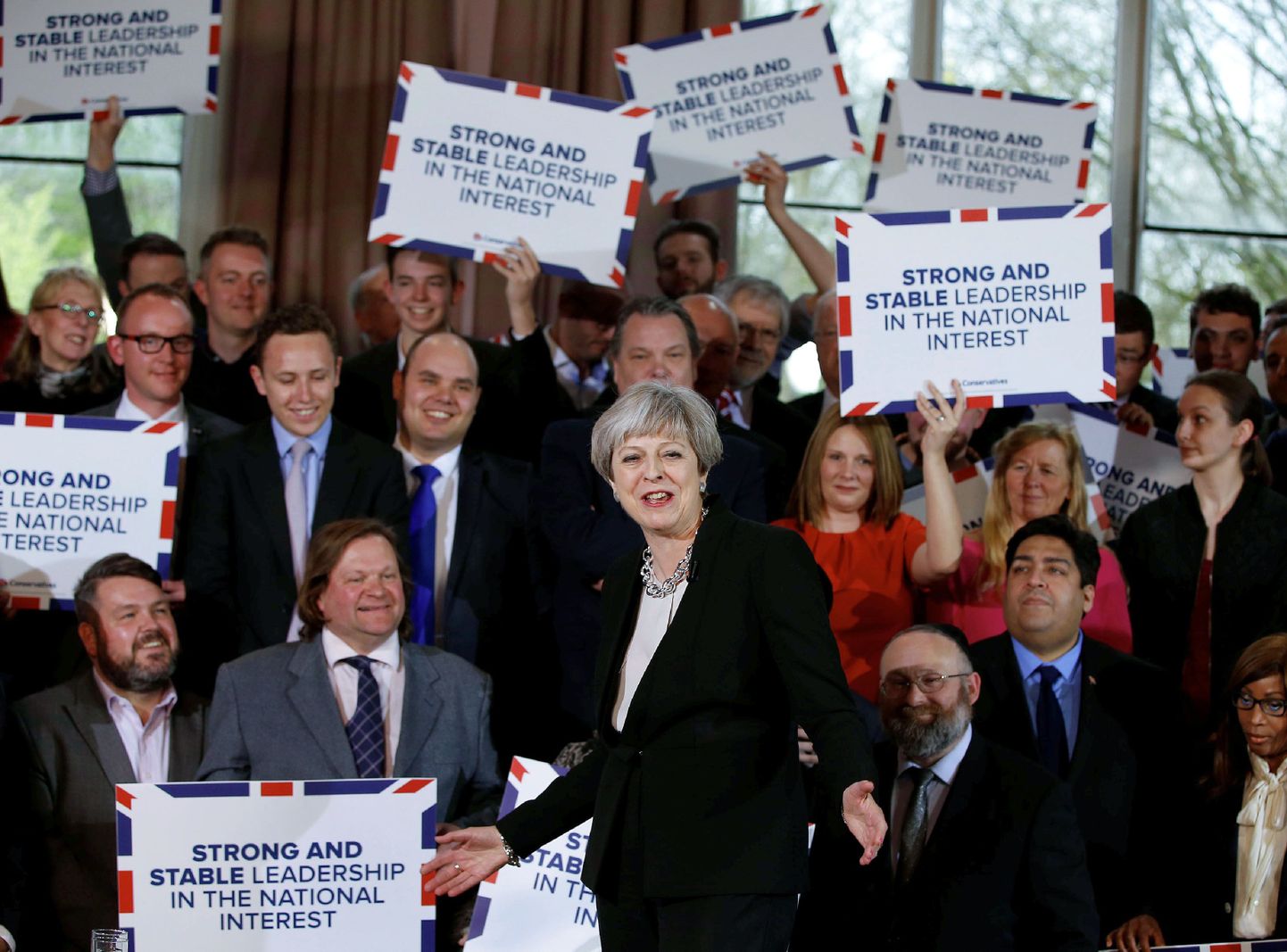 Briti peaminister Theresa May (keskel) konservatiividele kõnet pidamas.