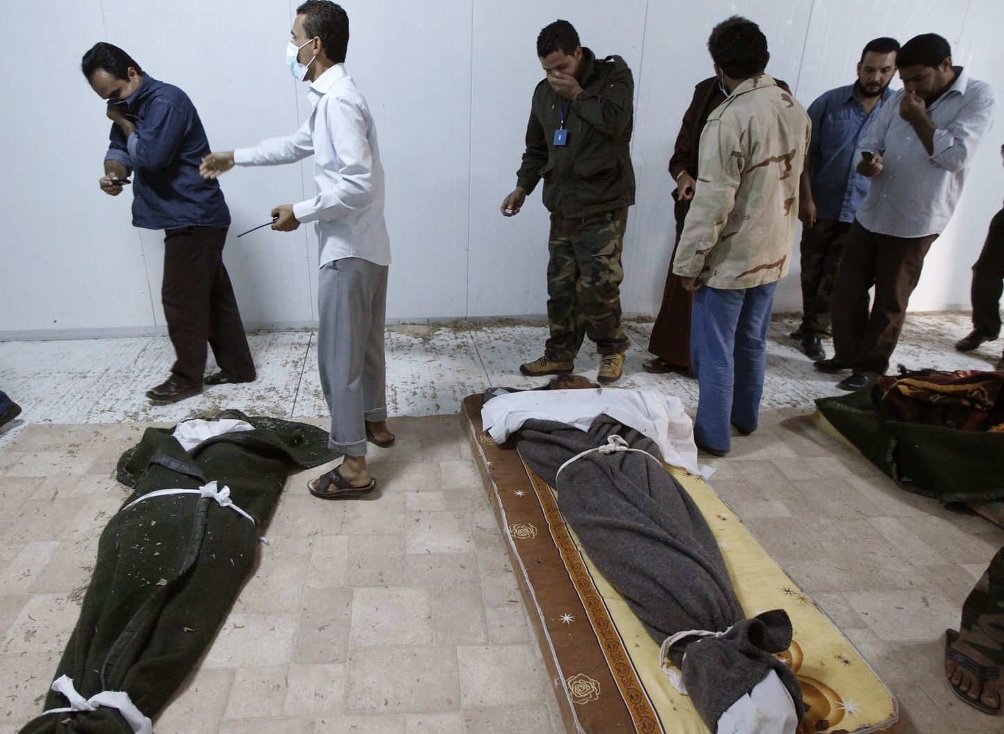 Liibüalased täna Misratah's Muammar Gaddafi ja tema kaasvõitlejate surnukehade juures.