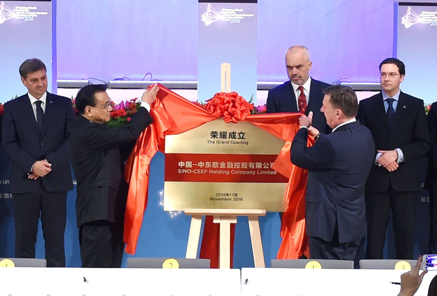 Hiina peaminister Li Keqiang (vasakul) ja Läti peaminister Maris Kucinskis (paremal) avavad pidulikult Kesk-ja Ida-Euroopa suunalise investeerimisfondi.