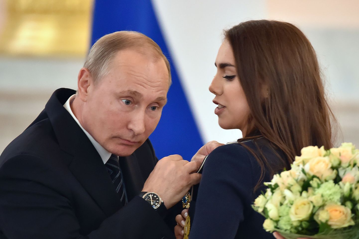 Olümpiasportlasi võõrustanud Venemaa president Vladimir Putin kinnitab ordeni rinda iluvõimlejale Margarita Mamunile.