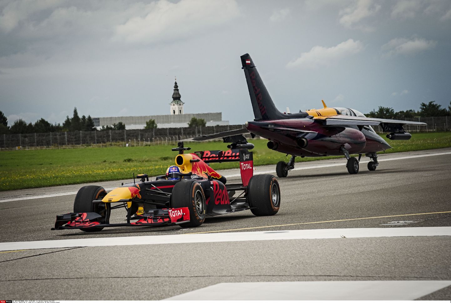 Болид Red Bull соревнуется с самолетом.