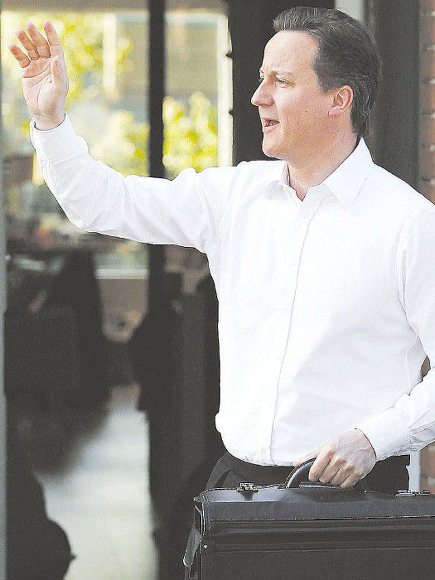 Лидер консерваторов Дэвид Кэмерон вчера утром перед своим лондонским домом готовится отправиться на переговоры о создании коалиции.