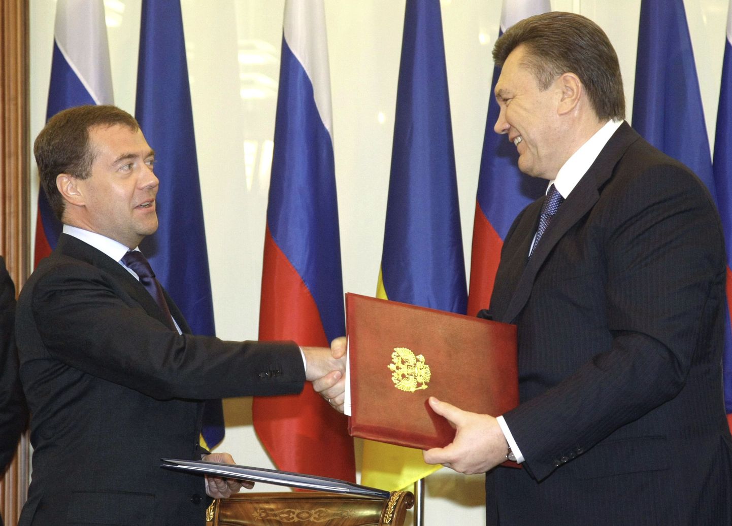 Дмитрий Медведев и Виктор Янукович обмениваются документами после подписания в Кракове 21 апреля 2010 года соглашения о ценах на газ.