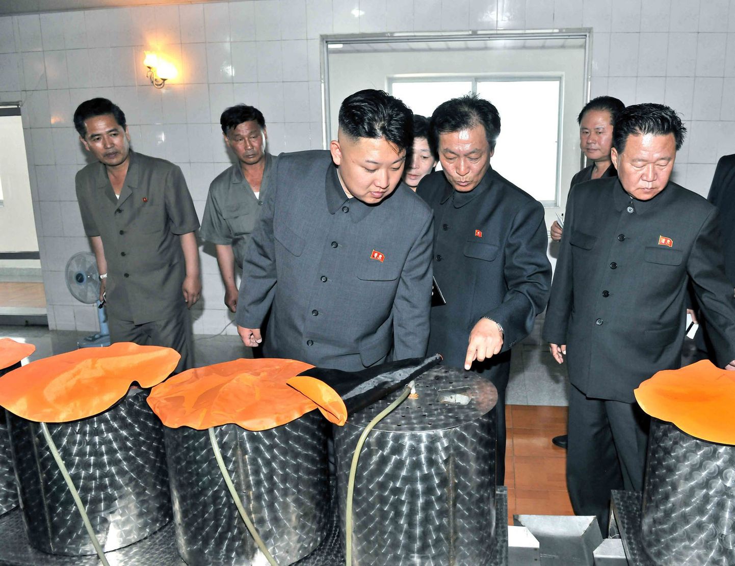 Põhja-Korea diktaator Kim Jong-un (keskel) tutvub Kanggye traktoritehase sööklas pakutavate toitudega.