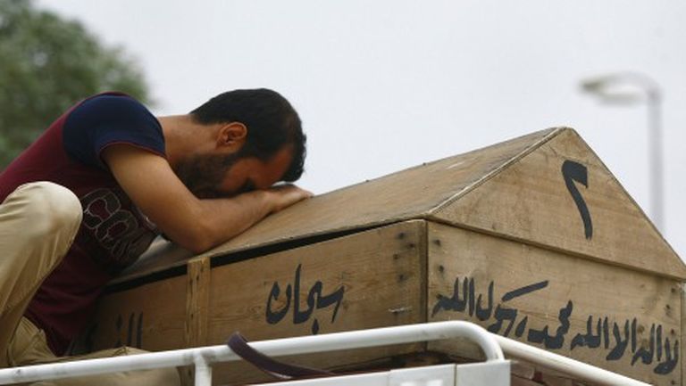 20 мая 2013 года. Мужчина плачет над гробом дочери, которая погибла во время волны взрывов в Багдаде 