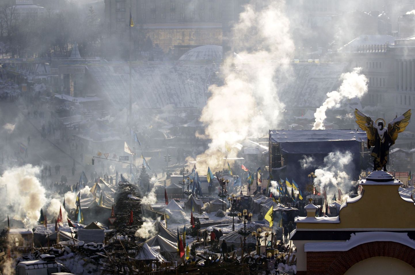 Ukraina meeleavaldajate laagris Kiievi kesklinnas tõusevad lõketest suitsupilved.