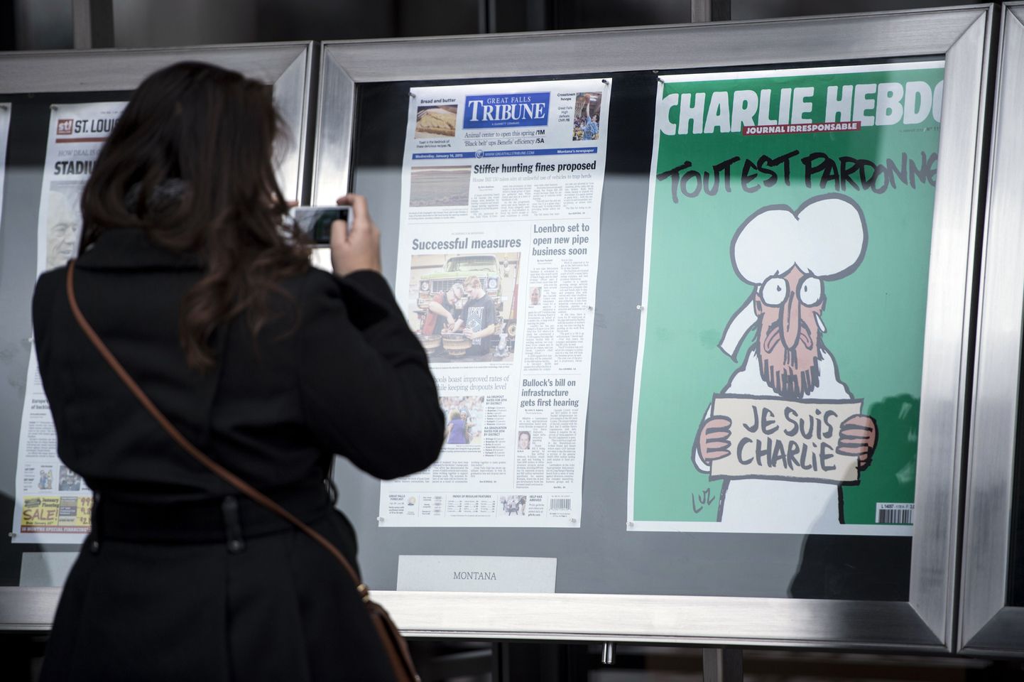 Naine pildistab satiirilehe Charlie Hebdo värske numbri esikülge.