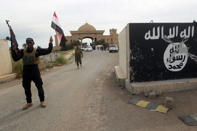 Šiiavõitlejad Tikritis Iraagi lippudega, nende kõrval on näha niinimetatud Islamiriigi toetajate loosung.