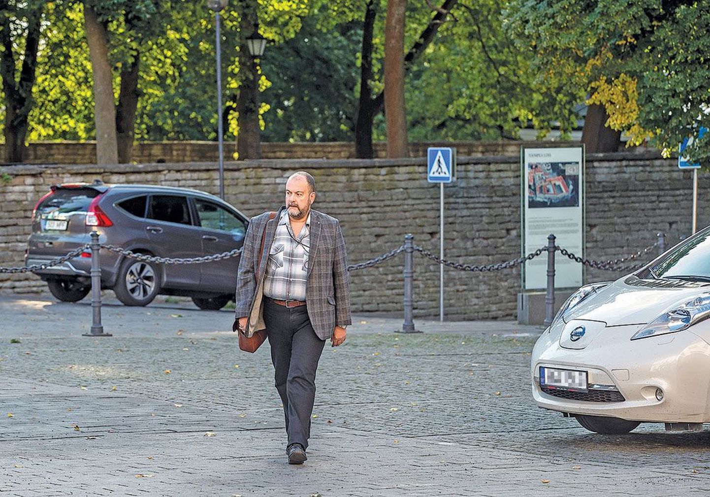 Депутат Михаил Стальнухин направляется на работу в Рийгикогу. На заднем плане виден предположительно тот самый автомобиль его жены, который был взят в лизинг и оплачивается с помощью депутатских компенсаций.