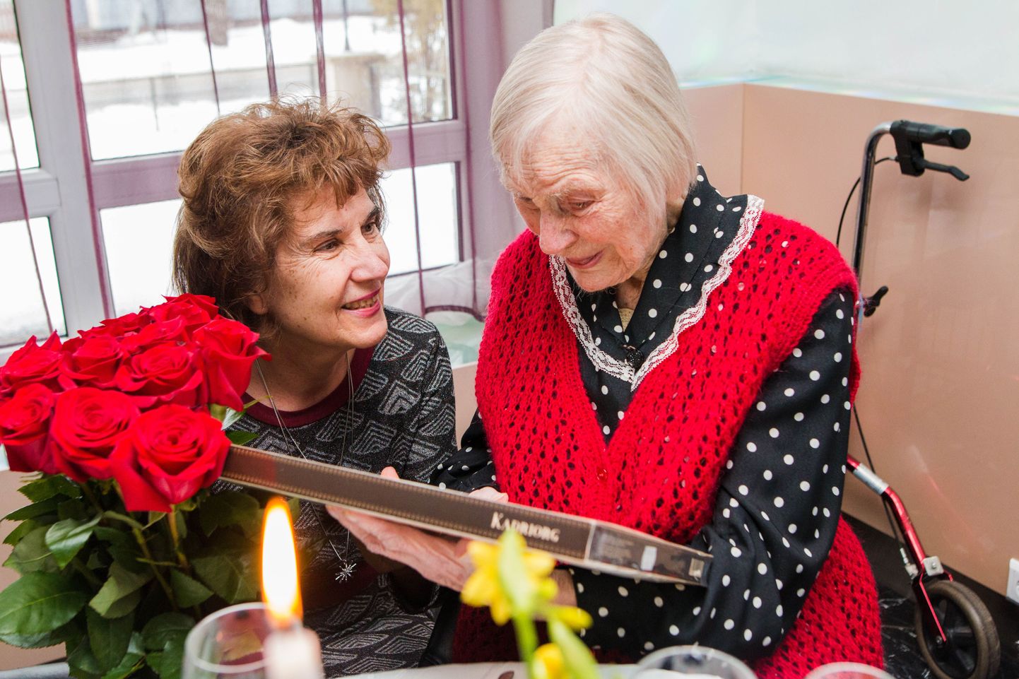 Pärnu abilinnapea Jane Mets annab 103aastaseks saanud Maire Midrile üle lilled ja kommikarbi.
