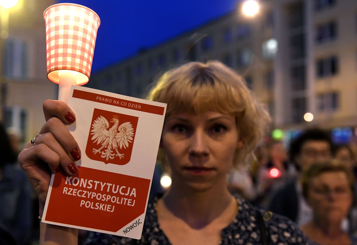 Justiitsreformi vastane meeleavaldaja Poola põhiseadust käes hoidmas.