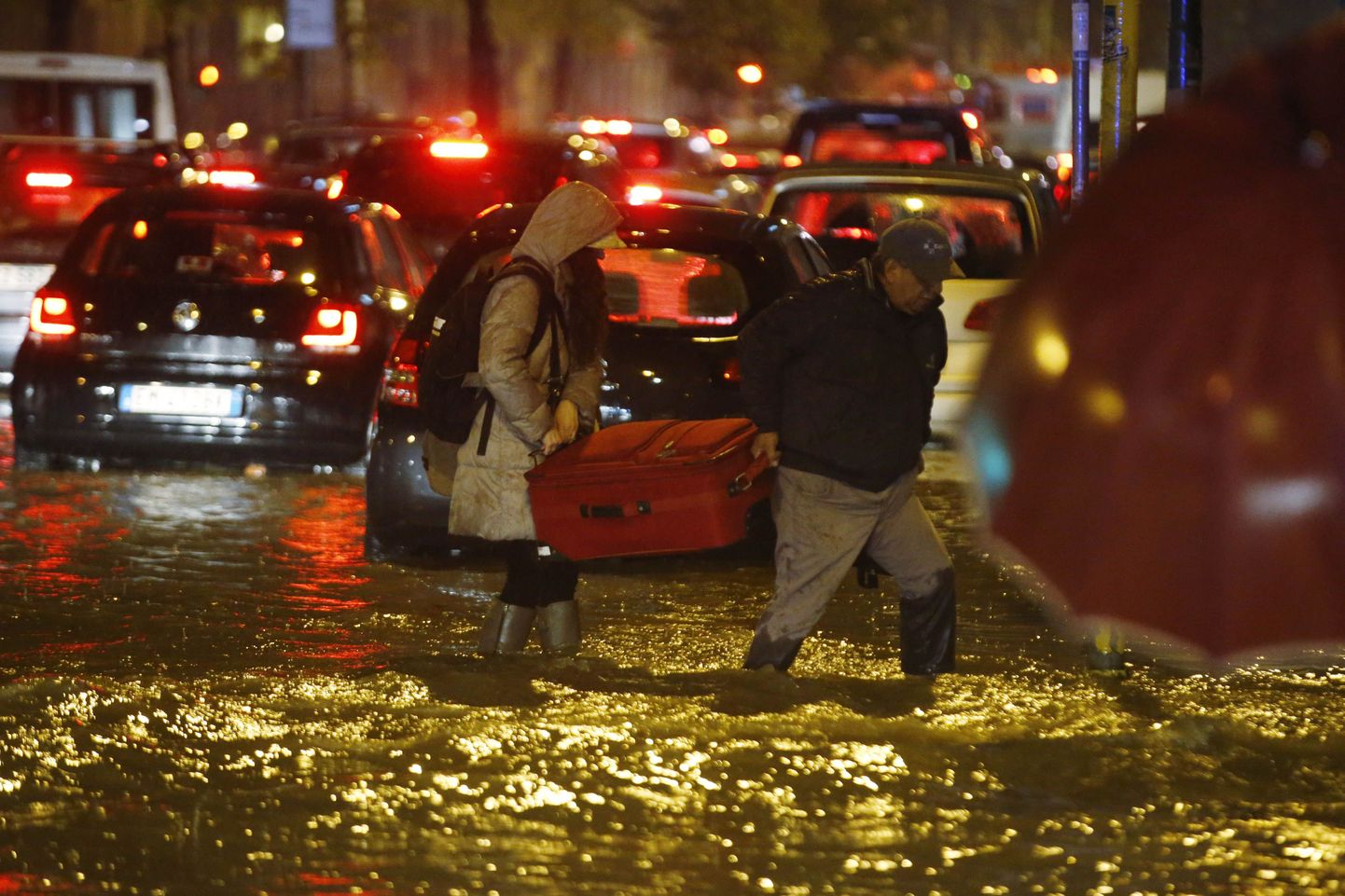 Mees ja naine tassivad kohvrit Milanos, kus Seveso jõgi kerkis üle kallaste.