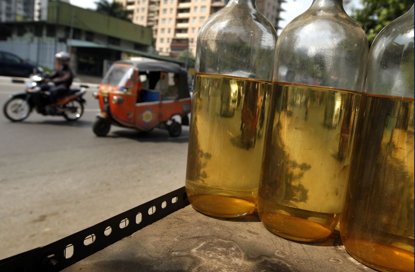 Jakarta tänaval müüakse bensiini liitristes pudelites. Pilt on tehtud Indoneesia pealinnas eile, 10. juulil.