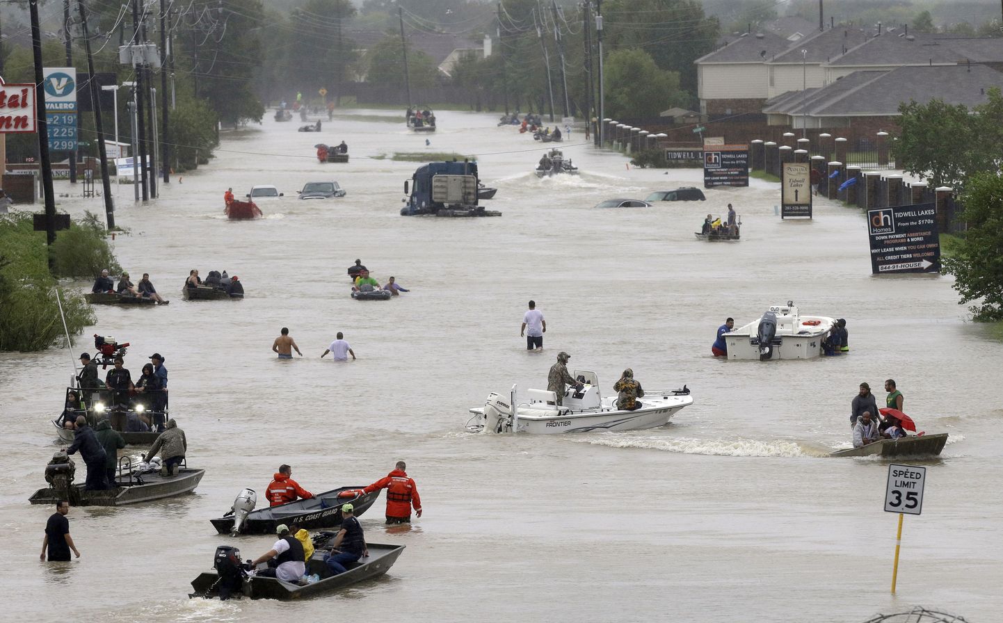 People and rescue boats line a street at the east Sam Houston Tollway as rescues continue from flooding following Tropical Storm Harvey. (Melissa Phillip/Houston Chronicle via AP)
