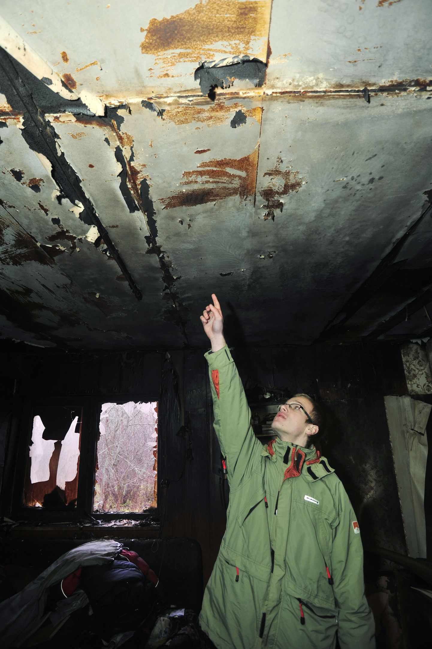 Leekidest pääsenud Janar Aunapuu näitab põlenud toa lage, kus asus teda unest äratanud suitsuandur.