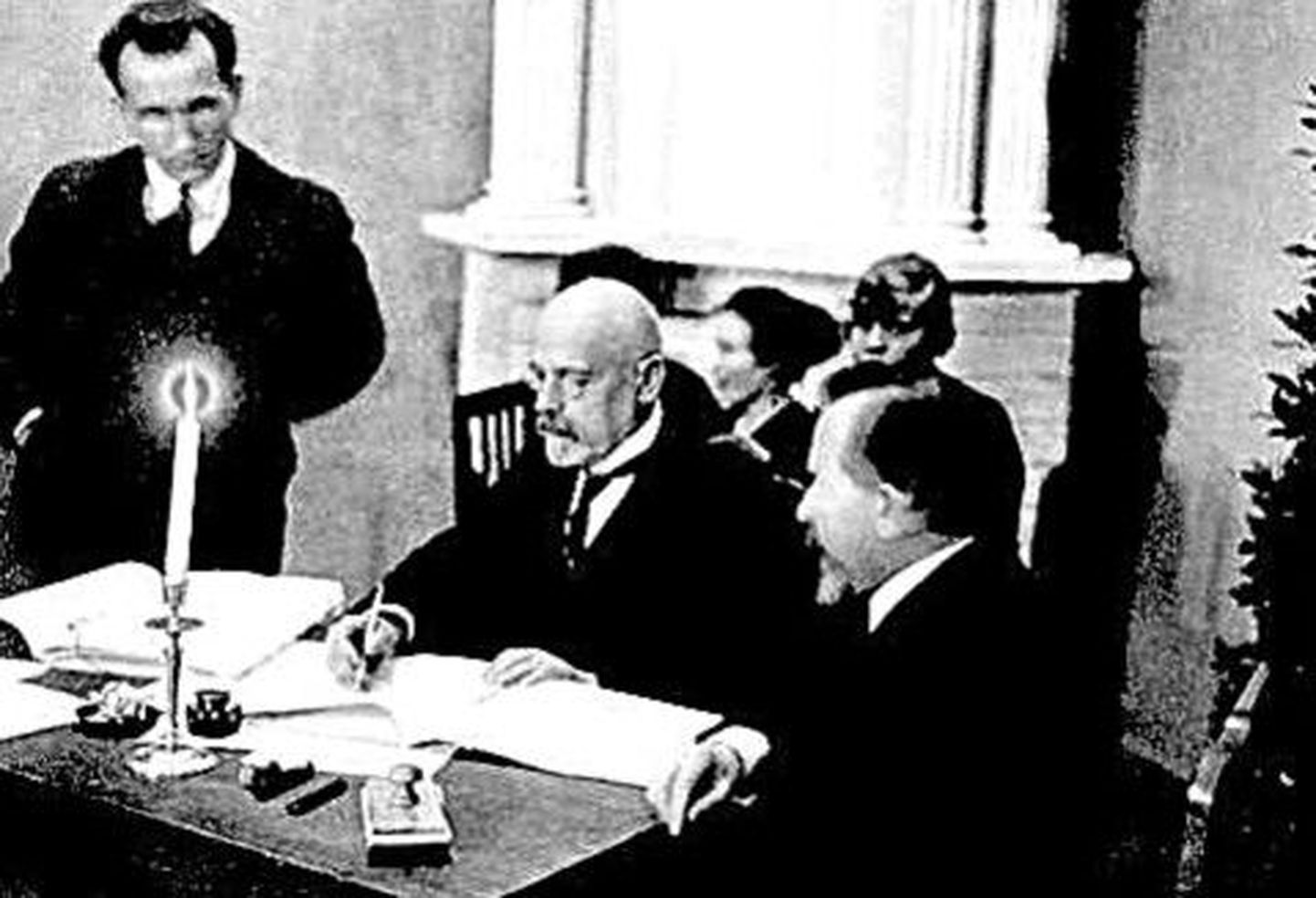 Руководитель эстонской делегации Яан Поска (в цент­ре) подписывает Тартуский мирный договор.