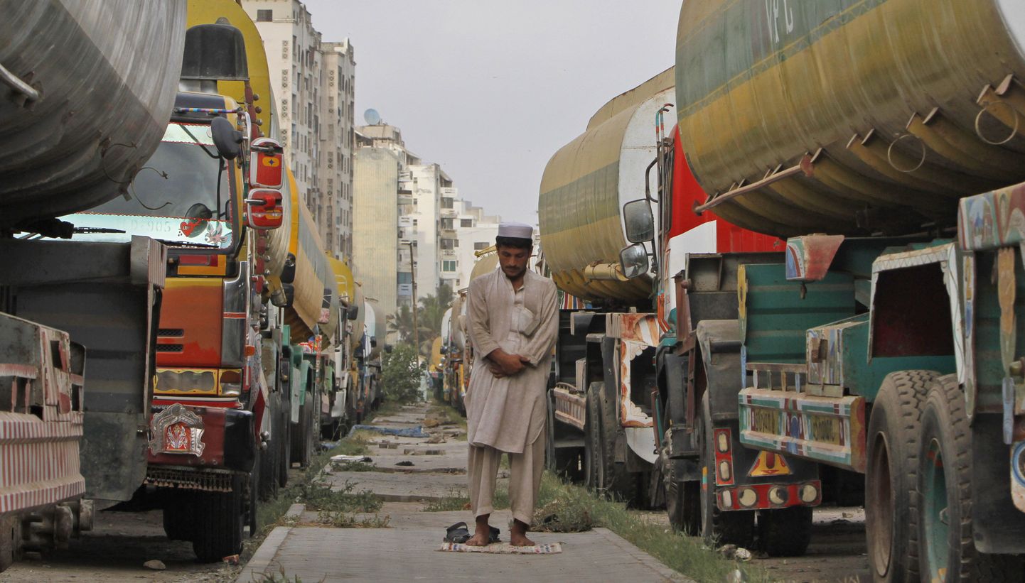 Pakistani mees eile palvetamas naftatankrite vahel, mida varem kasutati NATOle kütusevarude vedamiseks Afganistani.