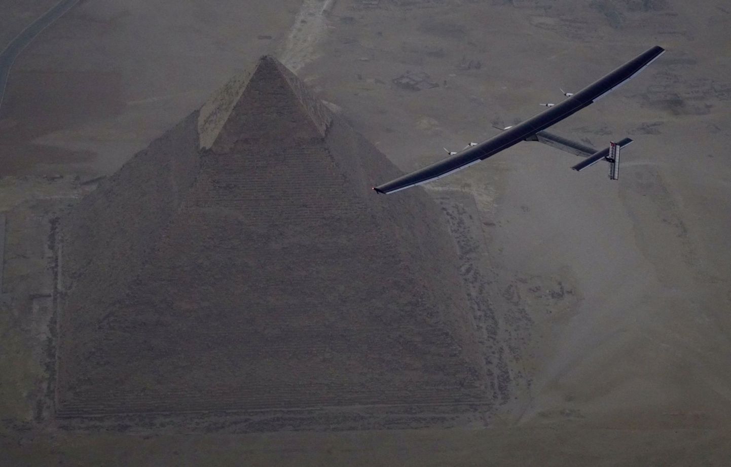 Solar Impulse 2, the solar powered plane, piloted by Swiss pioneer Andre Borschberg is seen during the flyover of the pyramids of Giza on July 13, 2016 prior to the landing in Cairo, Egypt in this photo released on July 13, 2016. Jean Revillard/SI2/Handout via Reuters ATTENTION EDITORS - THIS IMAGE WAS PROVIDED BY A THIRD PARTY. FOR EDITORIAL USE ONLY. NO RESALES. NO ARCHIVES.