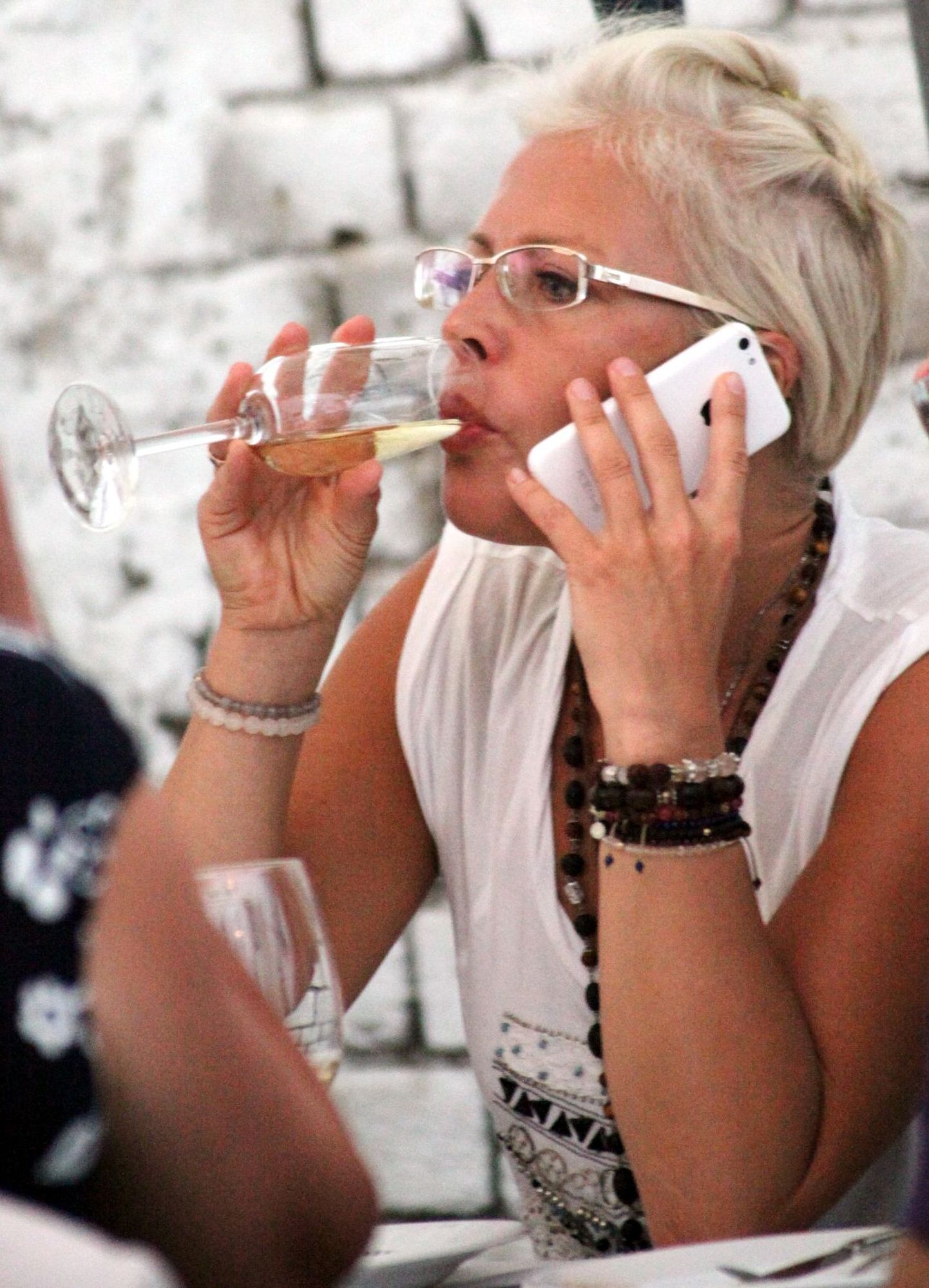 Evelin Ilves kallutas restoranis hoogsalt šampanjaklaasi ja losbises mobiiliga