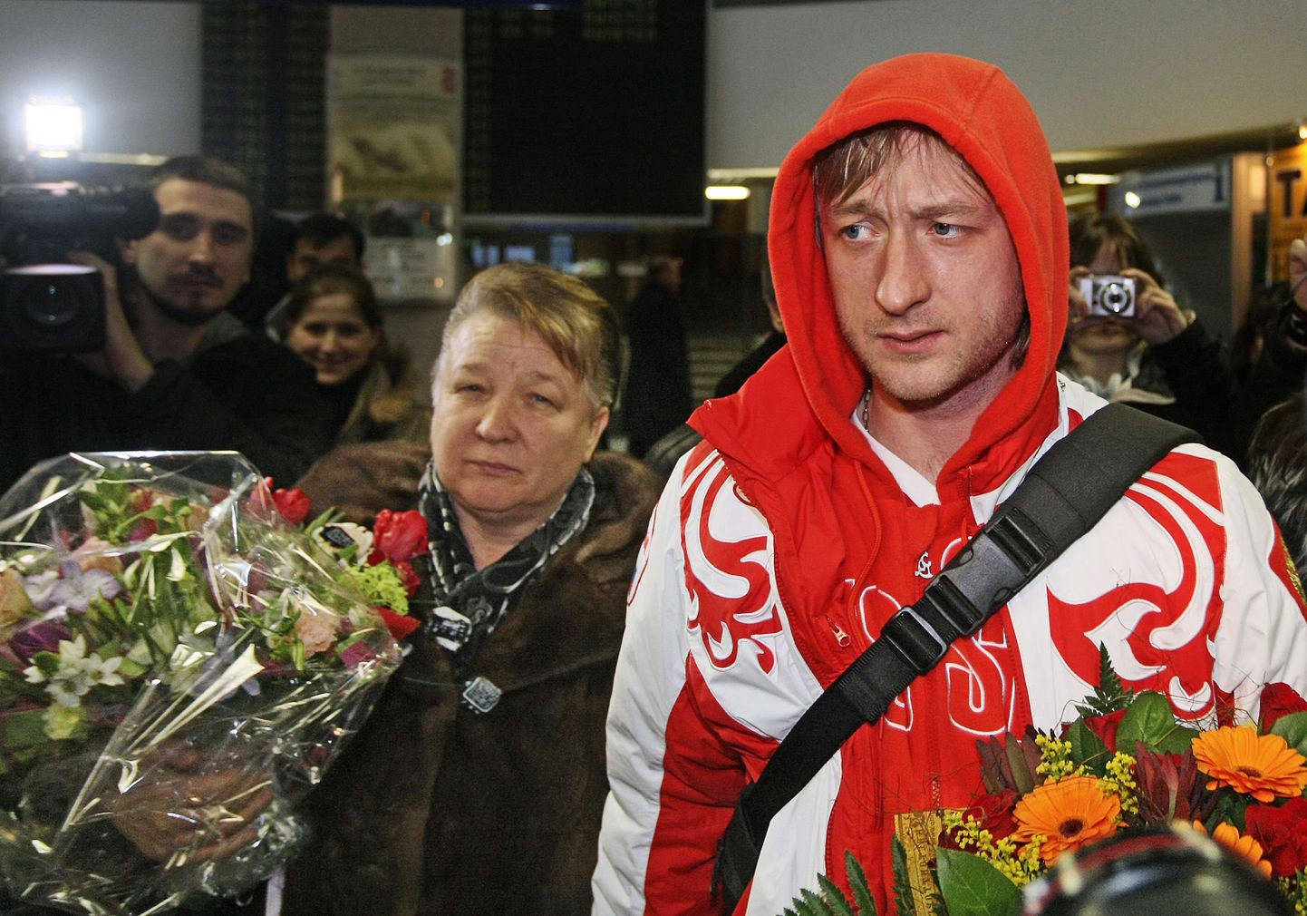Jevgeni Pljuštšenko olümpiamängudelt saabudes lennujaamas, tagaplaanil tema ema Tatjana.