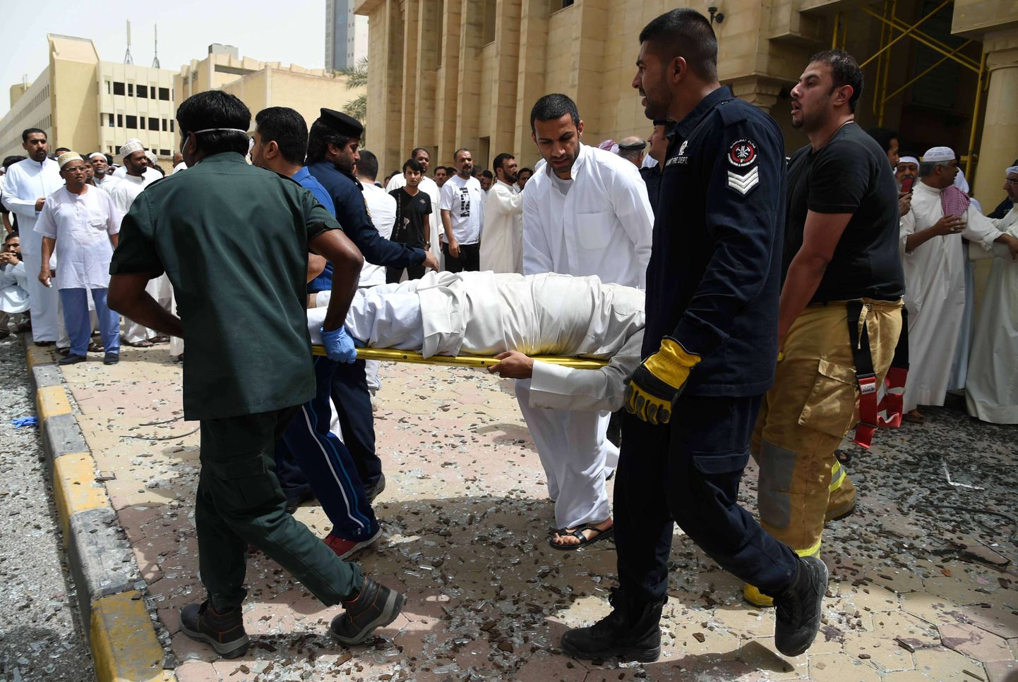 Kuveidi julgeoleku- ja meditsiinitöötajad kannavad välja ohvreid pärast eelmise aasta juunis šiiamošeele korraldatud terrorirünnakut.