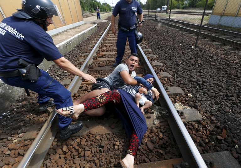 Mees, naine, laps ja Ungari politseinikud Bicske raudteejaamas.