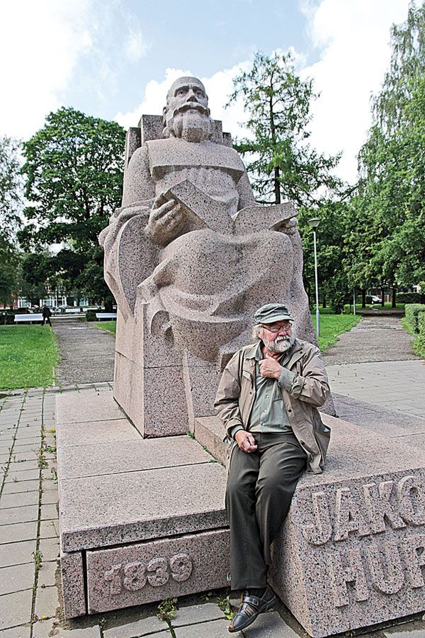 Jaak Soans istumas enda loodud Jakob Hurdaga Tartus, Vanemuise tänaval. Anno 2012.