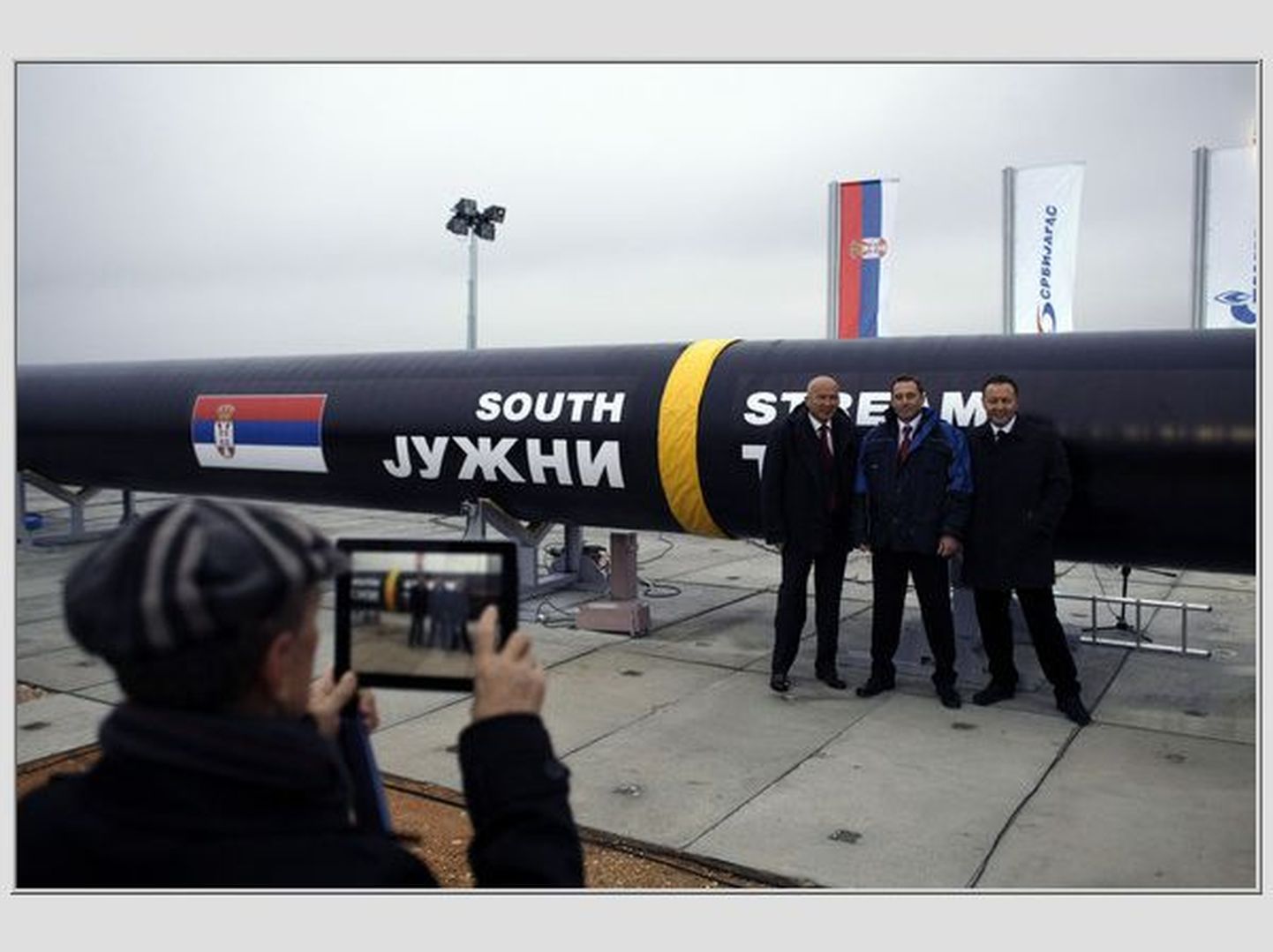 Inimesed Serbias Gazpromi torujuhtme taustal piltnikule poseerimas.
