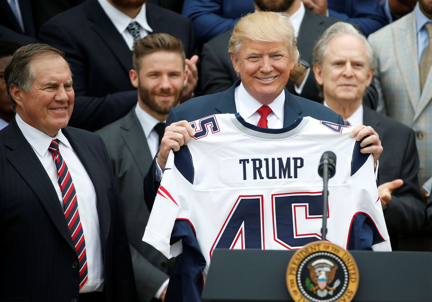 President Donald Trump hoiab käes enda nimega New England Patriotsi särki. Vasakul meeskonna peatreener Bill Belichick, kes on presidendile korduvalt ja tuliselt toetust avaldanud.