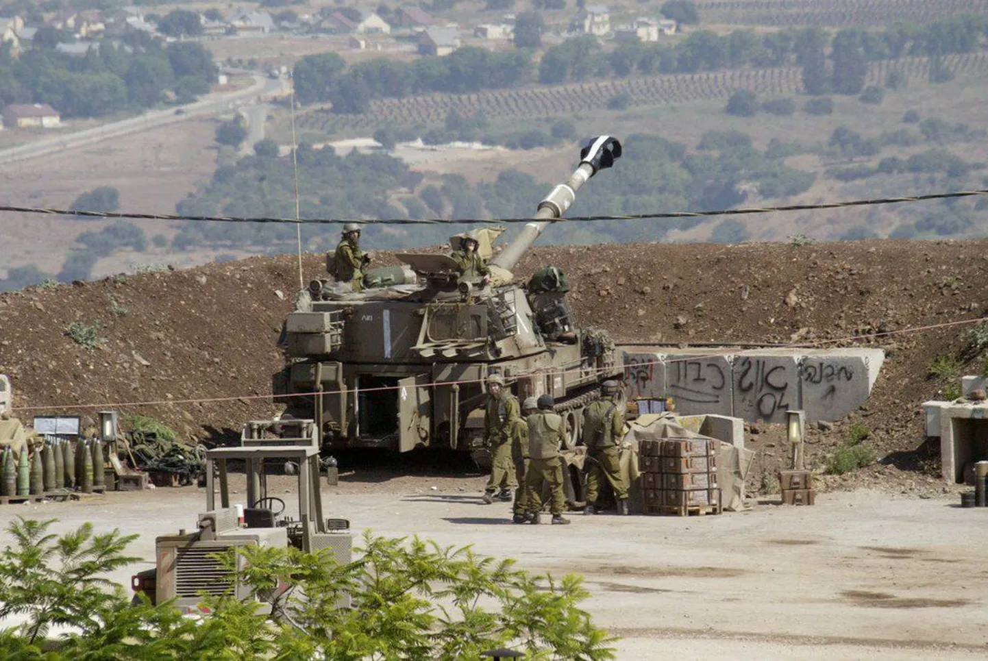 Израильские солдаты наносят удар по боевикам с помощью мобильной артиллерийской установки.