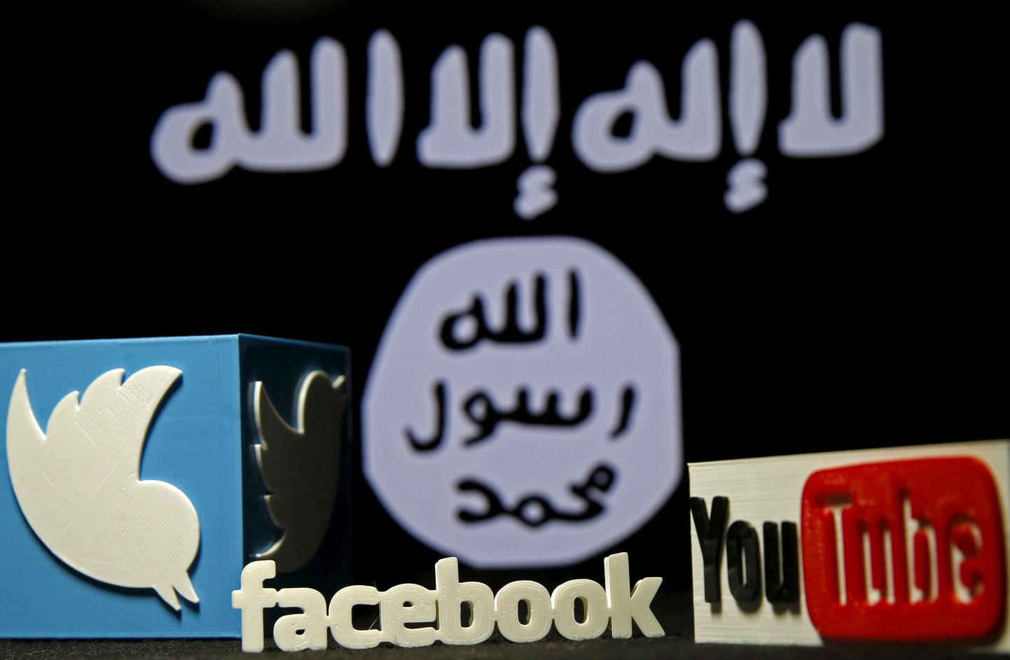 Facebooki, Twitteri ja Youtube'i logod ISISe lipu ees.