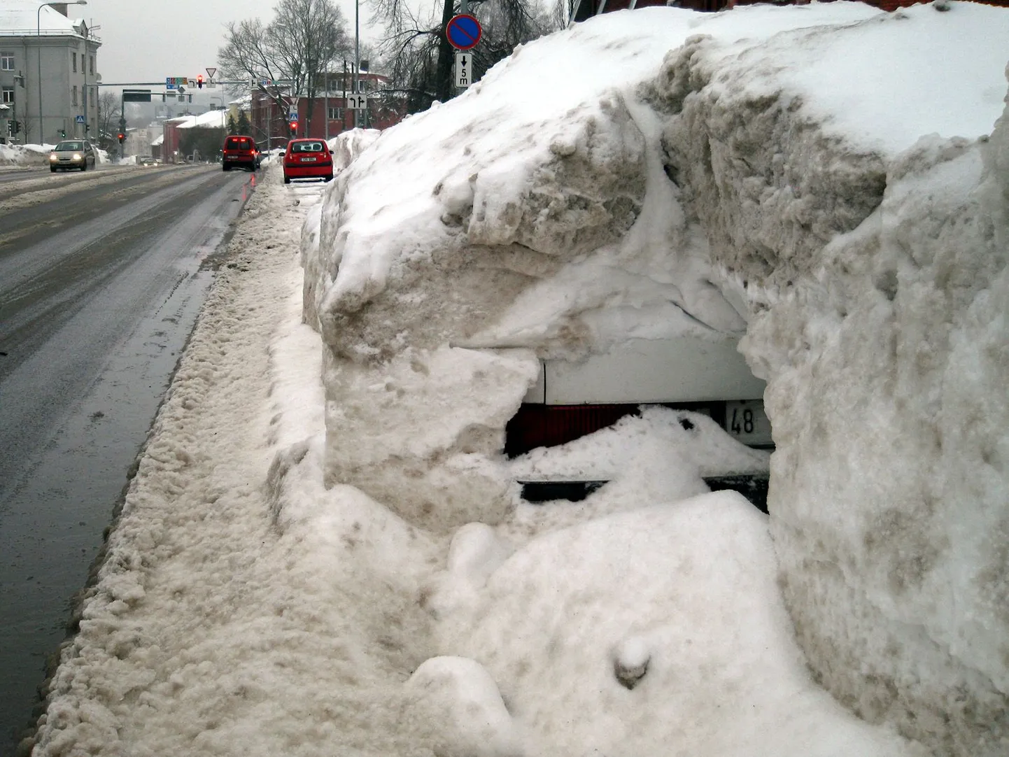 See Tartus Narva maanteel kõrge lumehange alla mattunud auto oleks äärepealt lõhkunud tänavapuhastustehnika.
