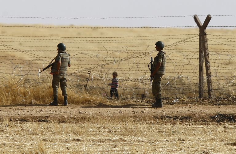 Türgi-Süüria piir. Ühel pool aeda Türgi sõdurid, teisel pool Süüria poiss. Foto: Scanpix