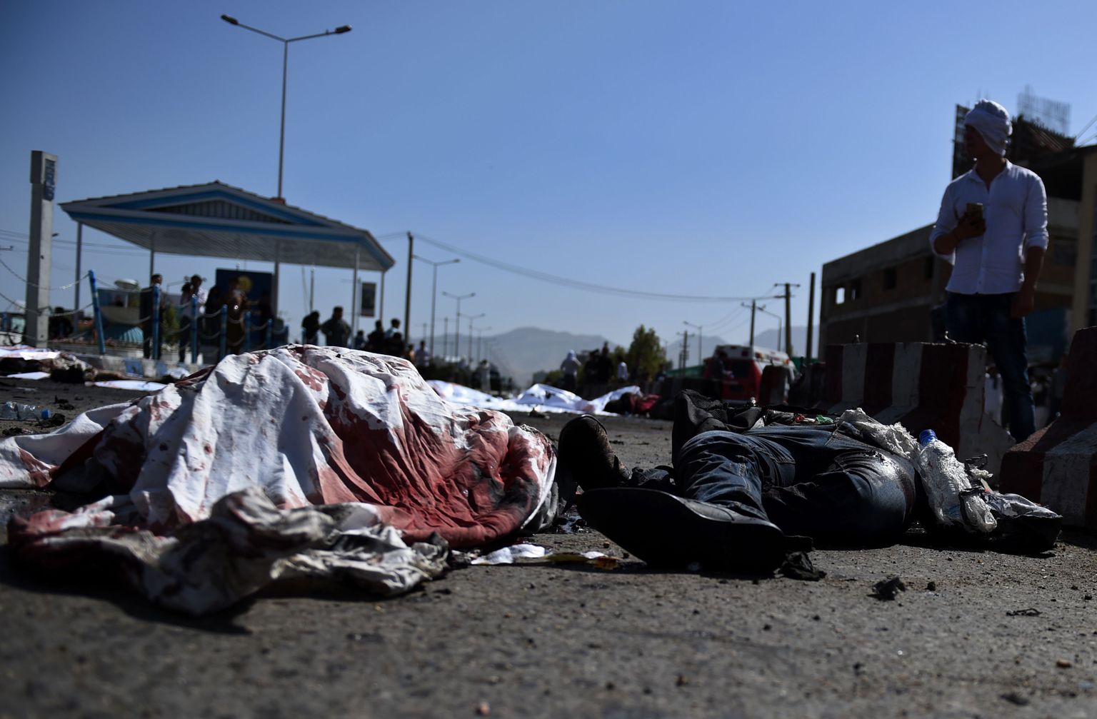 An Afghan protester stands near the bodies of victims at the scene of a suicide attack that targeted crowds of minority Shiite Hazaras during a demonstration at the Deh Mazang Circle of Kabul on July 23, 2016.
Islamic State jihadists claimed responsibility for twin explosions
July 23 that ripped through crowds of Shiite Hazaras in Kabul, killing at least 61 people and wounding 207 others in apparently their deadliest attack in the Afghan capital. The bombings during a huge protest over a power transmission line could deepen sectarian divisions in a country well known for communal harmony despite decades of war.
/ AFP PHOTO / WAKIL KOHSAR