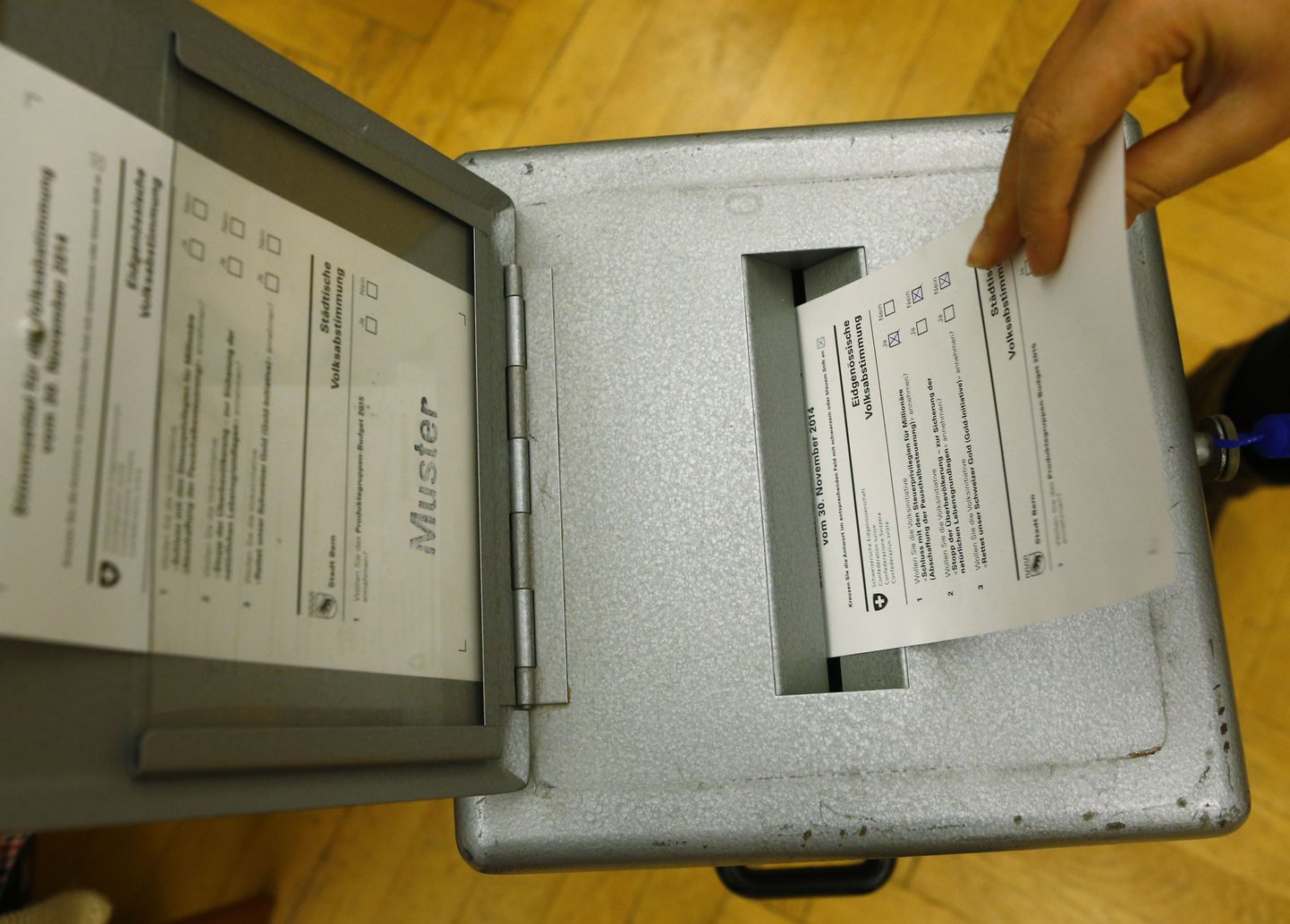Mees lükkab oma hääletussedelit kasti Bernis Spitalackeri koolis asuvas valimisjaoskonnas.